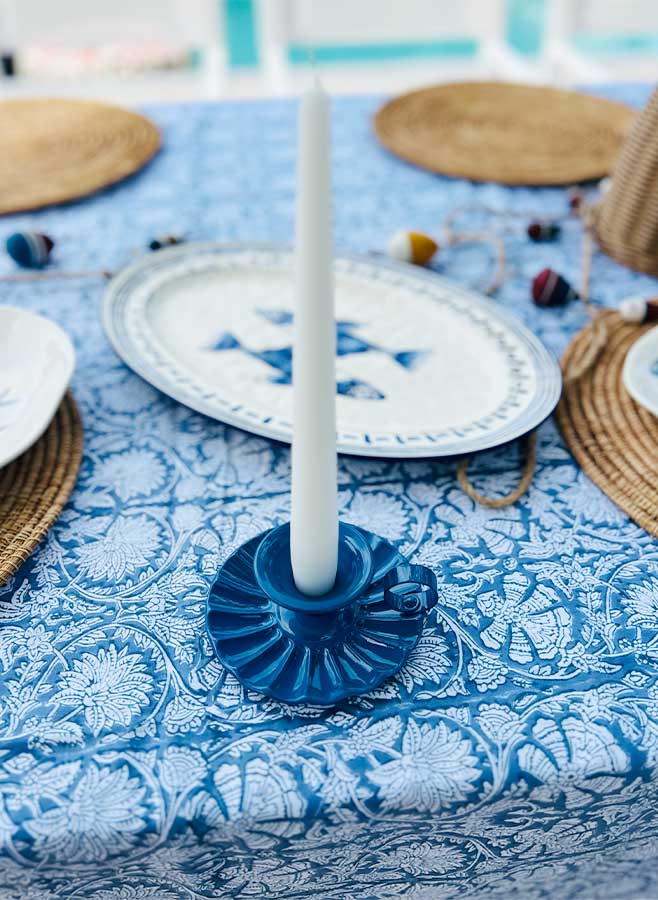 Blå ljusstake med handtag och vitt ljus på en blåmönstrad duk, italiensk vintagemodell från Ottinetti