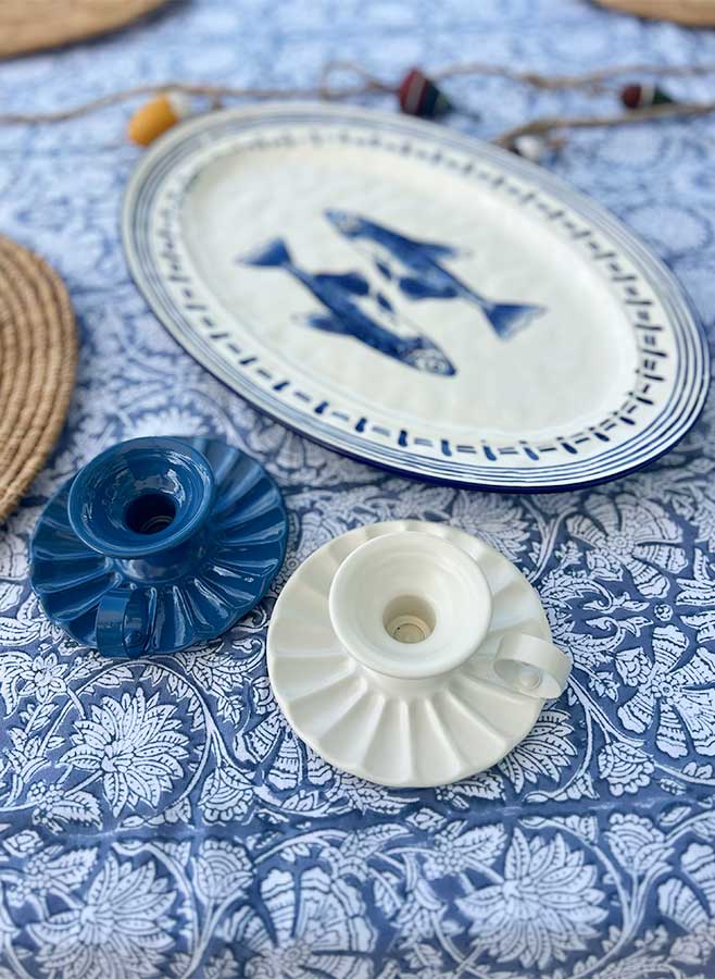 En blå och en vit ljusstake med handtag på en blåmönstrad duk, italienska vintagemodeller från Ottinetti
