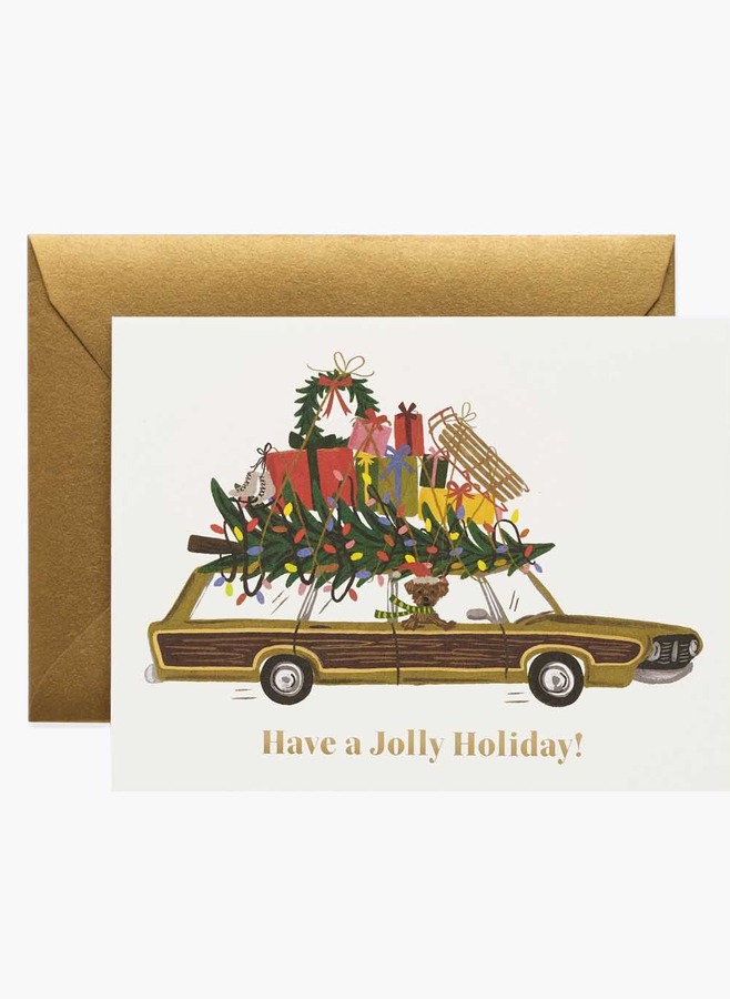 Julkort med en herrgårdsvagn lastad med julgran och julklappar och texten Have a Jolly Holiday, med guldfärgat kuvert, från Rifle Paper Co.
